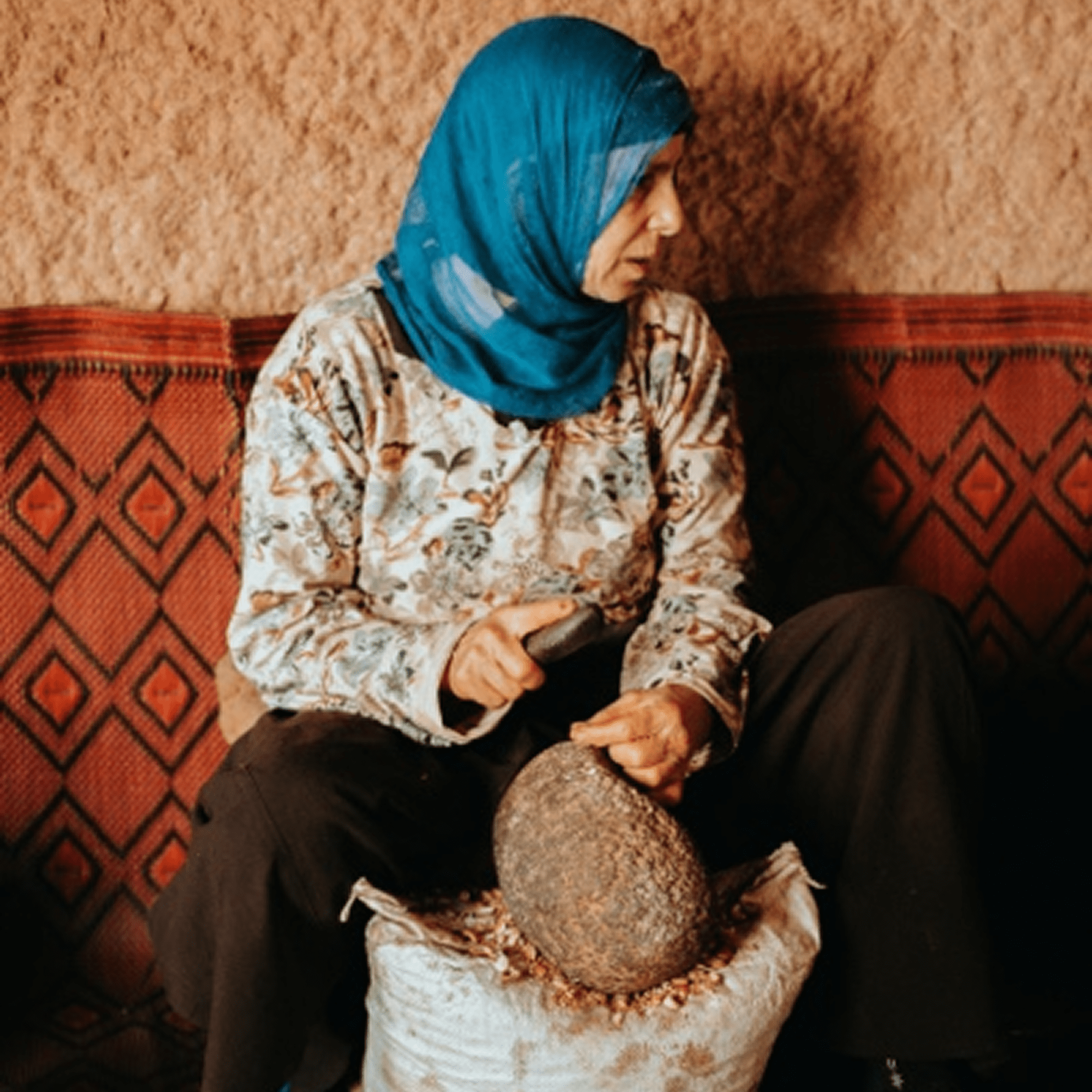 Lady uses stone grinder on seeds